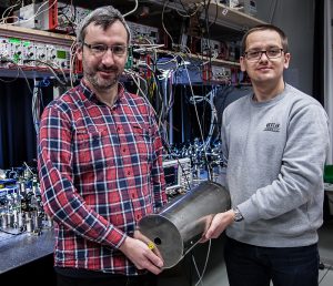 Wojciech Wasilewski (left) and Michal Dabrowski from the Faculty of Physics at the University of Warsaw demonstrate the single photon generator based on holographic quantum memory. Here, the gas-filled glass cell is located inside the magnetic shield used to eliminate external disturbances. (Source: UW Physics, Mateusz Mazelanik) Wojciech Wasilewski (po lewej) i Micha³ D¹browski z Wydzia³u Fizyki Uniwersytetu Warszawskiego demonstruj¹ generator pojedynczych fotonów oparty na holograficznej pamiêci kwantowej. Komórka szklana z gazem znajduje siê tu wewn¹trz ekranu magnetycznego s³u¿¹cego do eliminowania zewnêtrznych zak³óceñ. (ród³o: FUW, Mateusz Mazelanik)