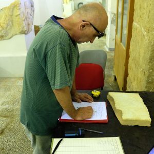 Prof. Adam Łajtar z Wydziału Archeologii UW opracowuje nowo odkrytą inskrypcję w Ptolemais. Fot. Piotr Jaworski