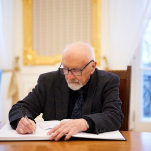 Prof. Jerzy Gaździcki, prezes Środowiska Żołnierzy Grupy Bojowej „Krybar” w Światowym Związku Żołnierzy AK, podpisuje księgę kondolencyjną podczas uroczystego spotkania poświęconego pamięci prof. Piotra Węgleńskiego. Fot. Mirosław Kaźmierczak/UW