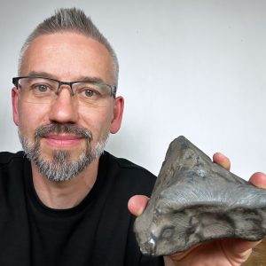 Prof. Szymon Kozłowski prezentuje nowy meteoryt. Źródło: Obserwatorium Astronomiczne UW